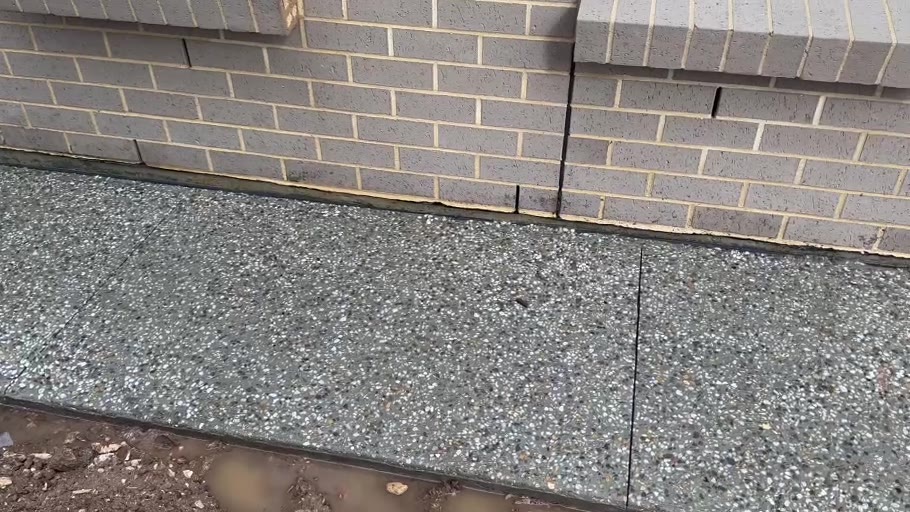 Exposed aggregate concrete path installed by ConcreteWorX SA beside a brick home